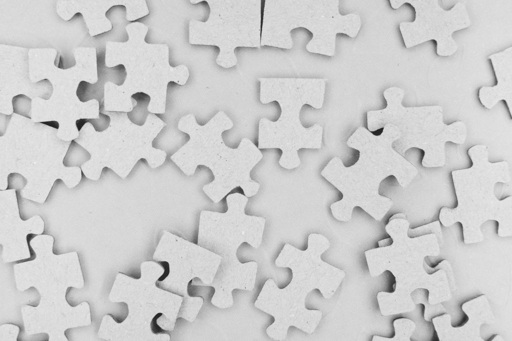 Loose jigsaw pieces scattered face-up, none yet joined &mdash; connected data that has not been linked into evidence.